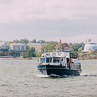 A boat drives in front of an island off Helsinki.