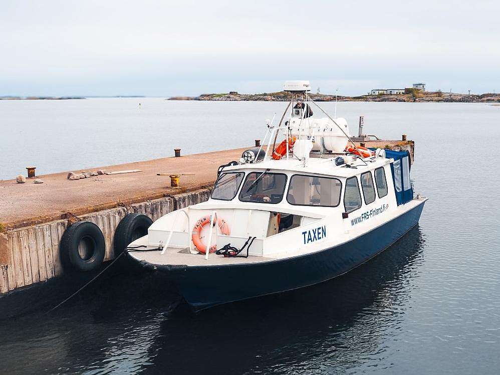 Pieni taksivene kiinnittyy saarien ympäröimään laituriin. 