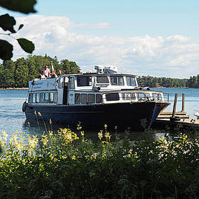Näkymä lautasta merellä vehreän saaristomaiseman keskellä.