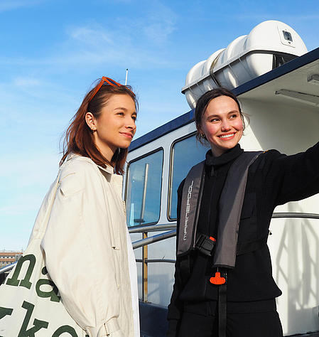 Two women are on a raft, and one of them is being given directions.