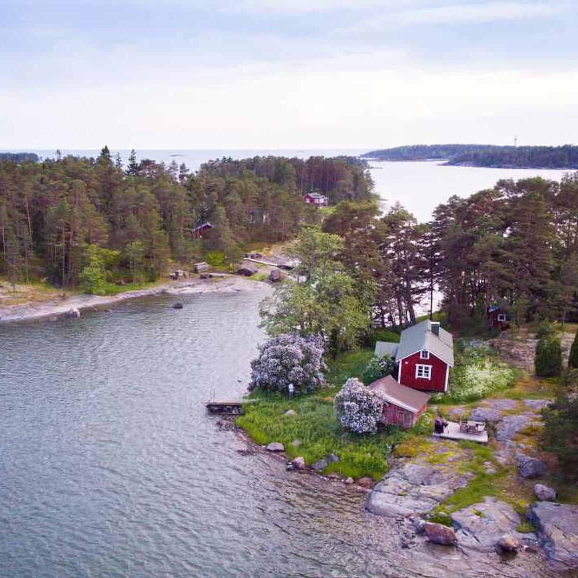 Archipelagoes from above with a red cabin and a lot of water around. 