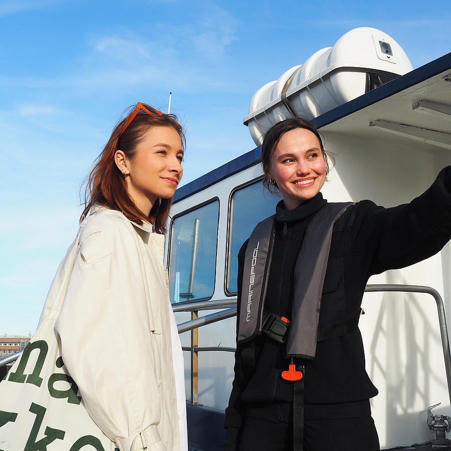 Two women are on a raft, and one of them is being given directions.