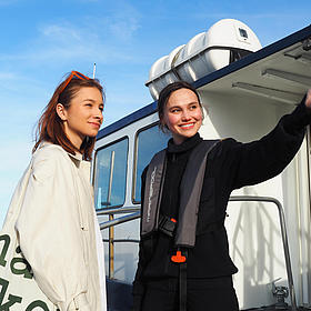 Two women are on a raft, and one of them is being given directions.