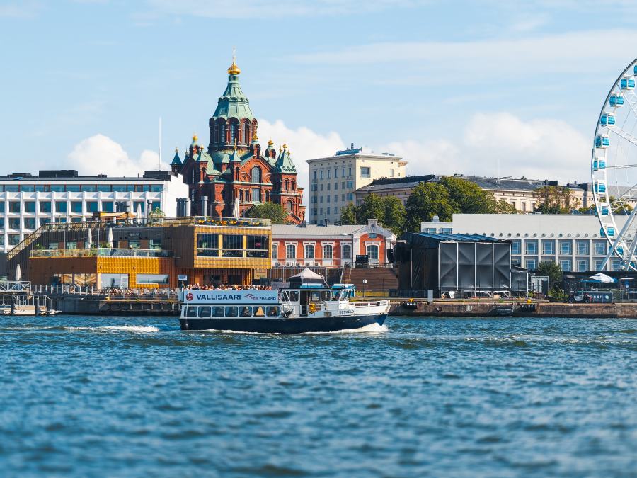 Helsingin ja maailmanpyörän taustalla kulkee laiva.